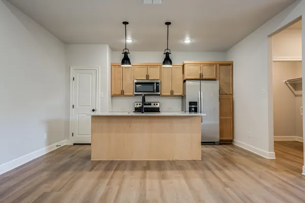 a large kitchen with cabinets and wooden floor