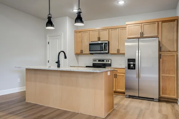 a kitchen with stainless steel appliances a refrigerator sink and microwave
