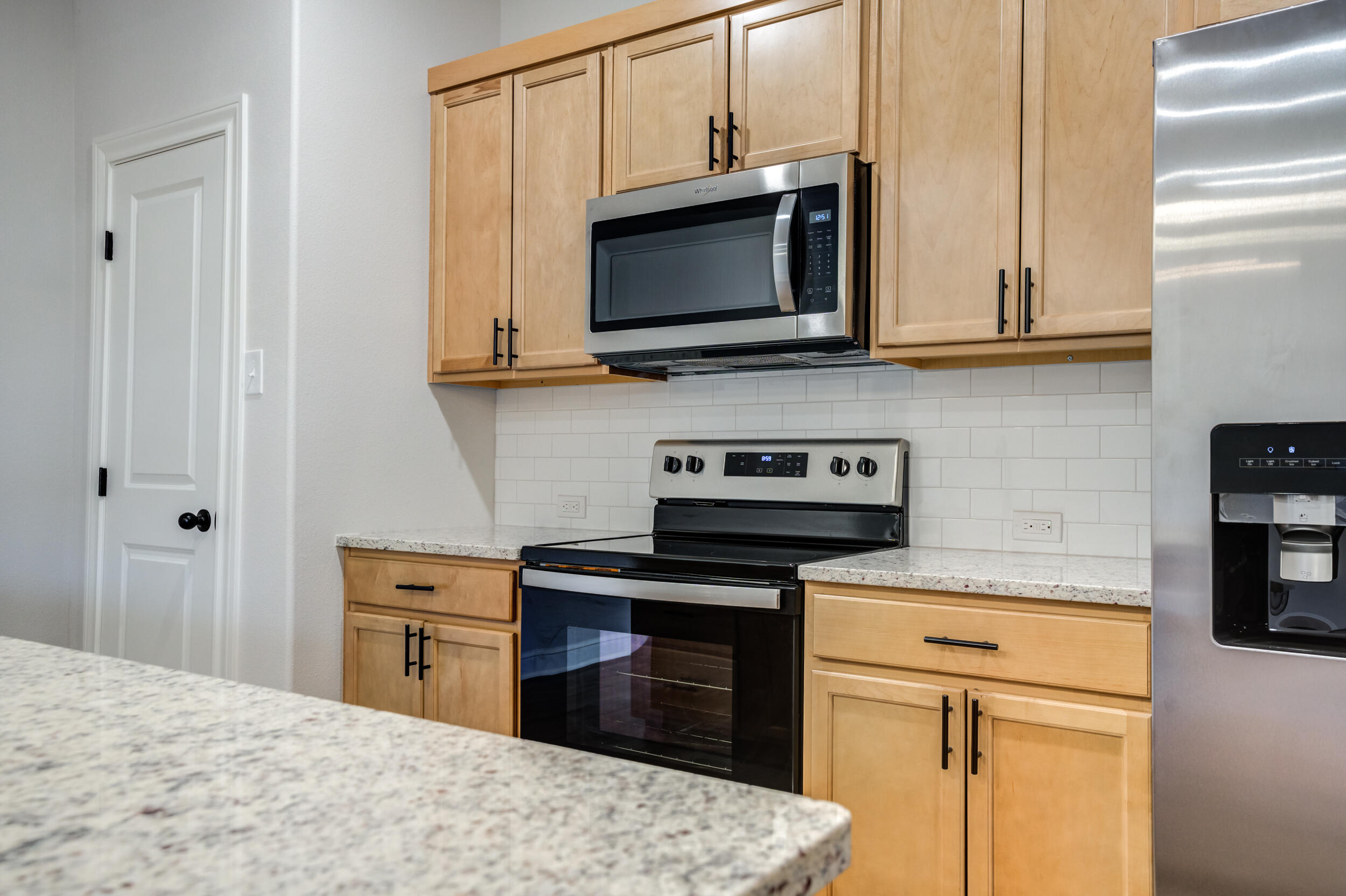 2534 137th Street Lubbock, TX 79423 - Photo 16 of 46 a kitchen with stainless steel appliances granite countertop a stove microwave and cabinets