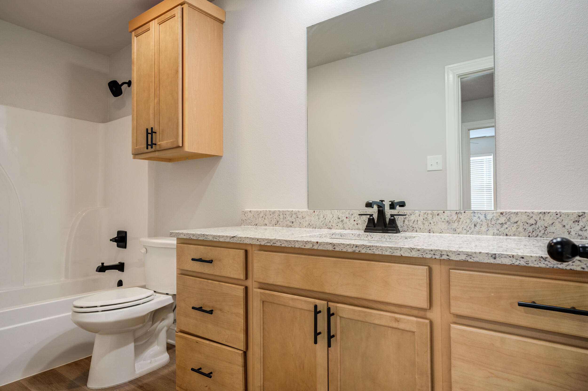 2534 137th Street Lubbock, TX 79423 - Photo 27 of 46 a bathroom with a granite countertop sink a toilet and mirror