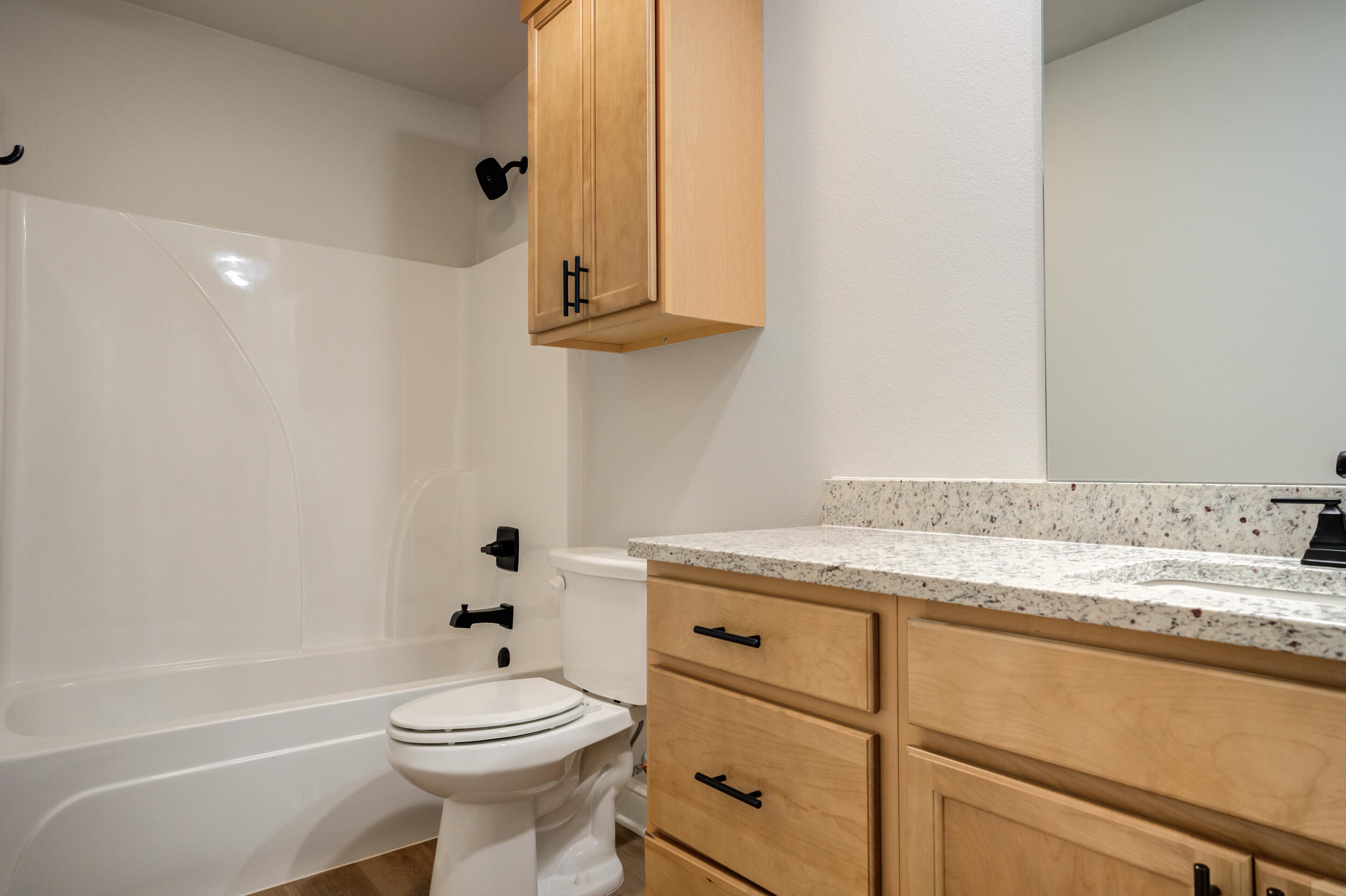 2534 137th Street Lubbock, TX 79423 - Photo 28 of 46 a bathroom with a granite countertop toilet sink and mirror