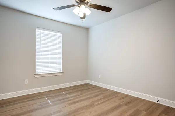 an empty room with a window and a ceiling fan