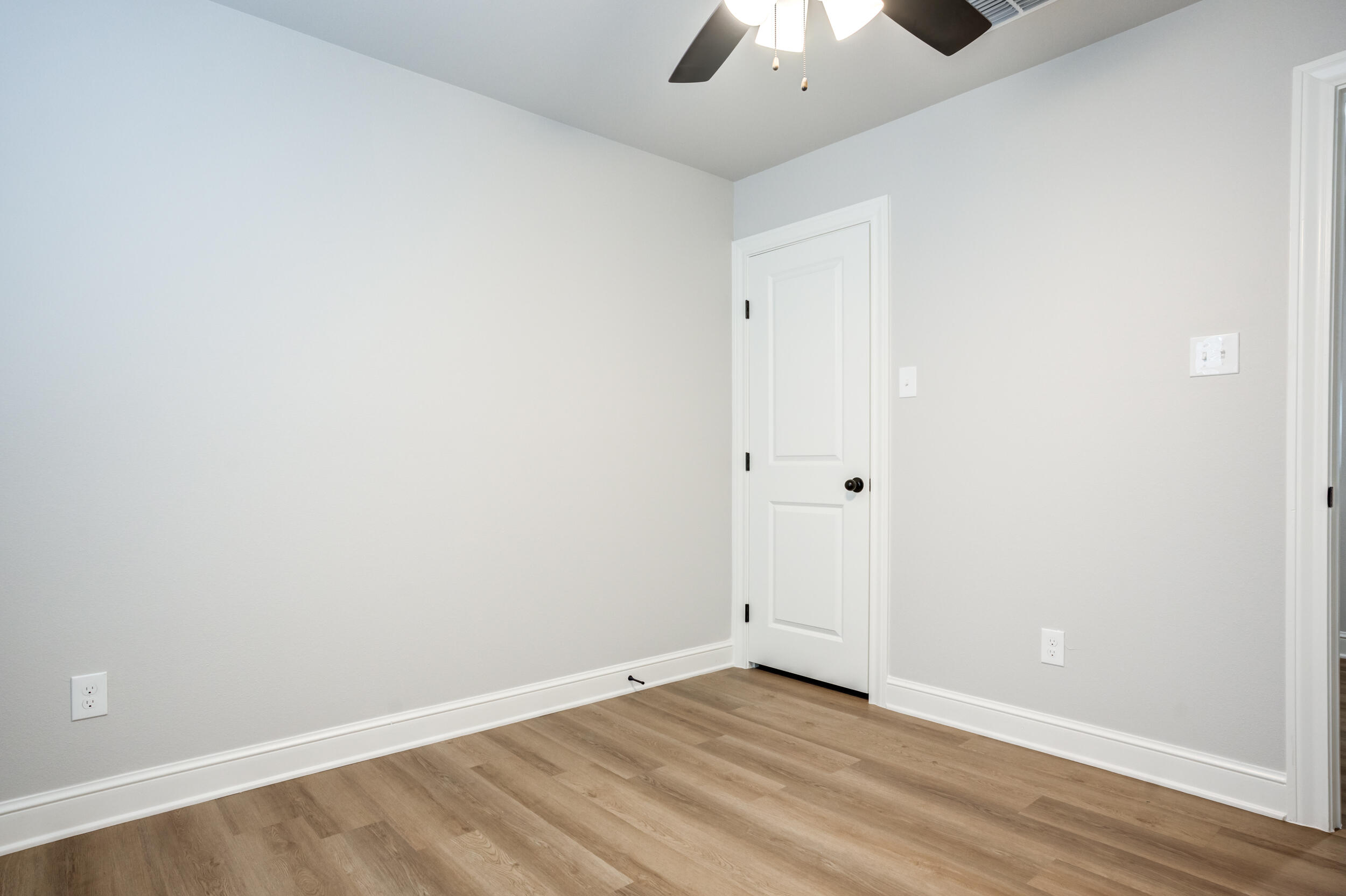 2534 137th Street Lubbock, TX 79423 - Photo 30 of 46 an empty room with a ceiling fan and wooden floor