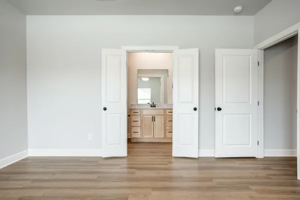 a view of a kitchen from the hallway with wooden floor