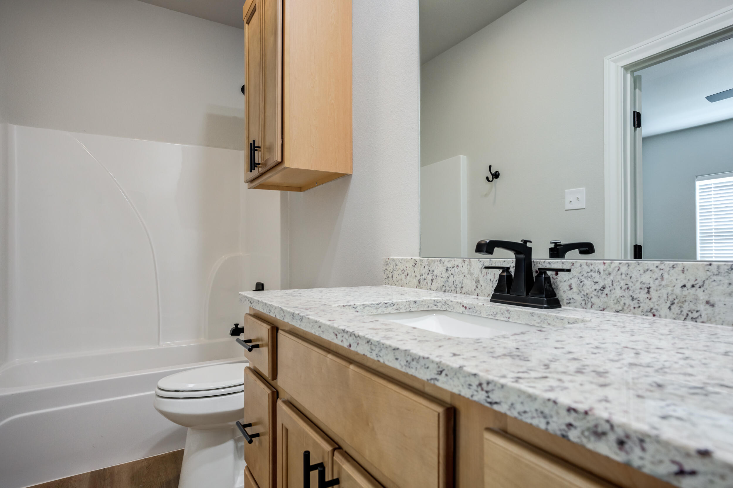 2534 137th Street Lubbock, TX 79423 - Photo 41 of 46 a bathroom with a granite countertop sink a toilet and a bathtub