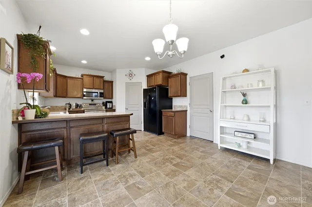 a kitchen with stainless steel appliances granite countertop a refrigerator and a stove top oven