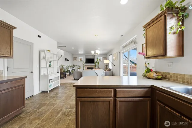a kitchen with stainless steel appliances kitchen island granite countertop a sink a stove and a refrigerator