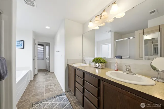 a bathroom with a sink double vanity granite and a mirror