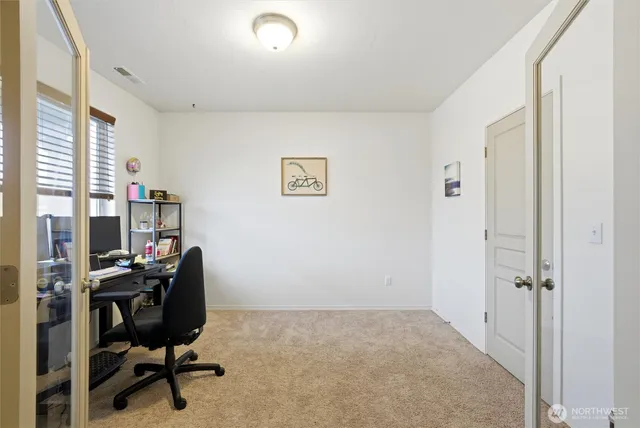 a view of a workspace with furniture and a window