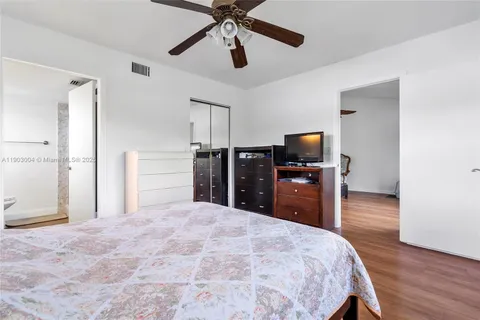 a bedroom with a bed and a flat tv screen on dresser