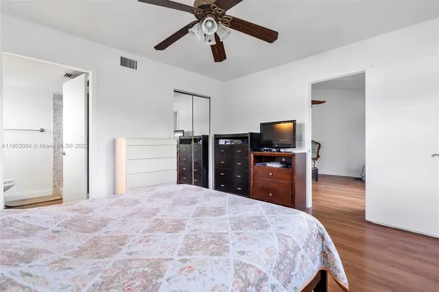 a bedroom with a bed and a flat tv screen on dresser