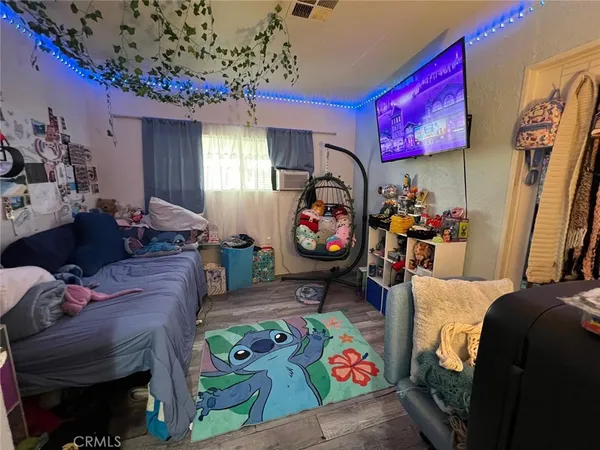 a bedroom with furniture and a flat screen tv