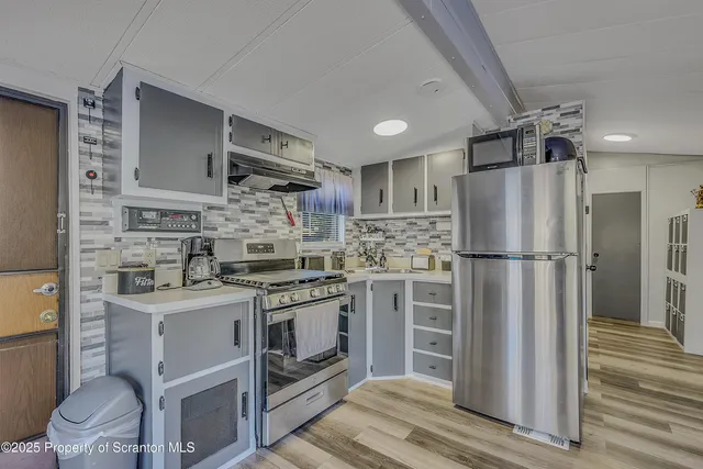 a kitchen with stainless steel appliances granite countertop a refrigerator stove and sink