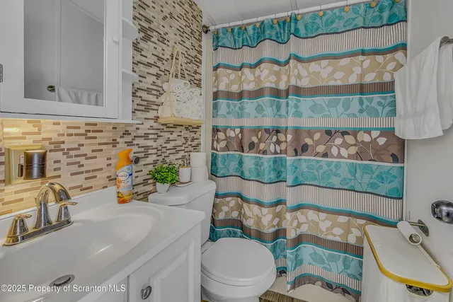 a bathroom with a sink mirror vanity and toilet