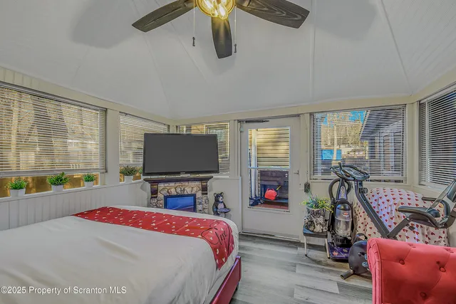 a bedroom with a bed a couch and large window