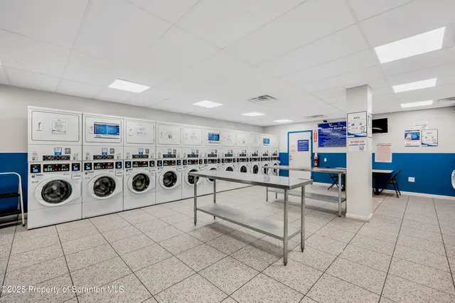 a room with stainless steel appliances kitchen island granite countertop a stove and a cabinets