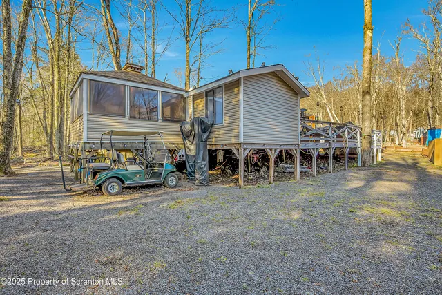 a view of a house with a yard and parking space