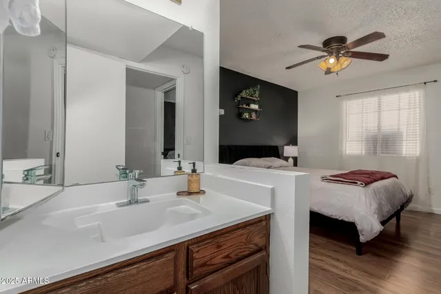a walk in closet with wooden floor