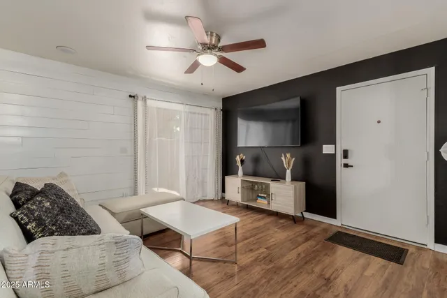 a living room with furniture and a ceiling fan