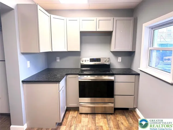 a kitchen with a stove and white cabinets