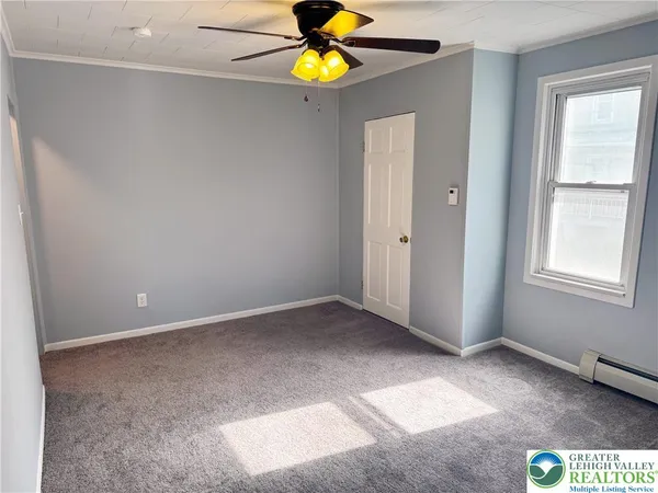 an empty room with windows and mirror