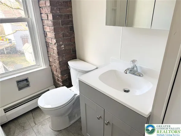 a white toilet sitting next to a bathroom sink