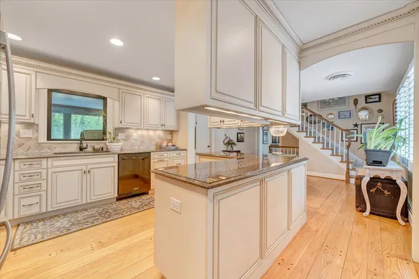 a kitchen with granite countertop a refrigerator stove and sink