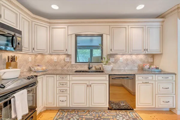 a kitchen with stainless steel appliances granite countertop a stove a sink and a refrigerator