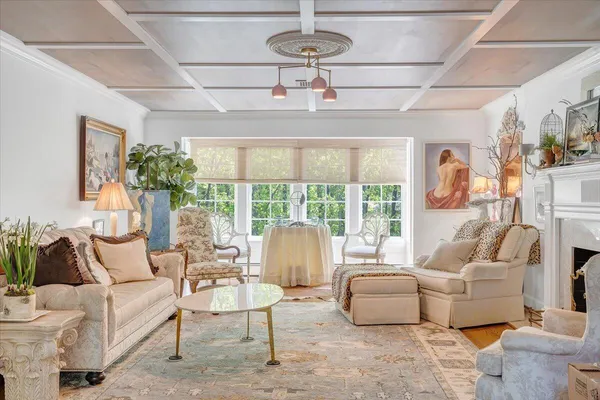 a living room with furniture large window and wooden floor