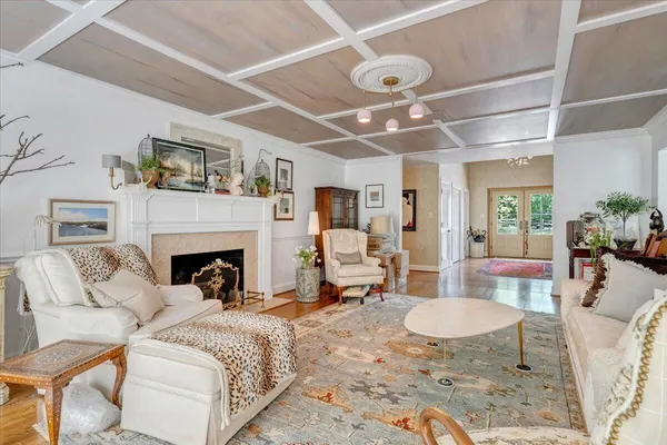 a dining room with wooden floor a chandelier a wooden table and chairs