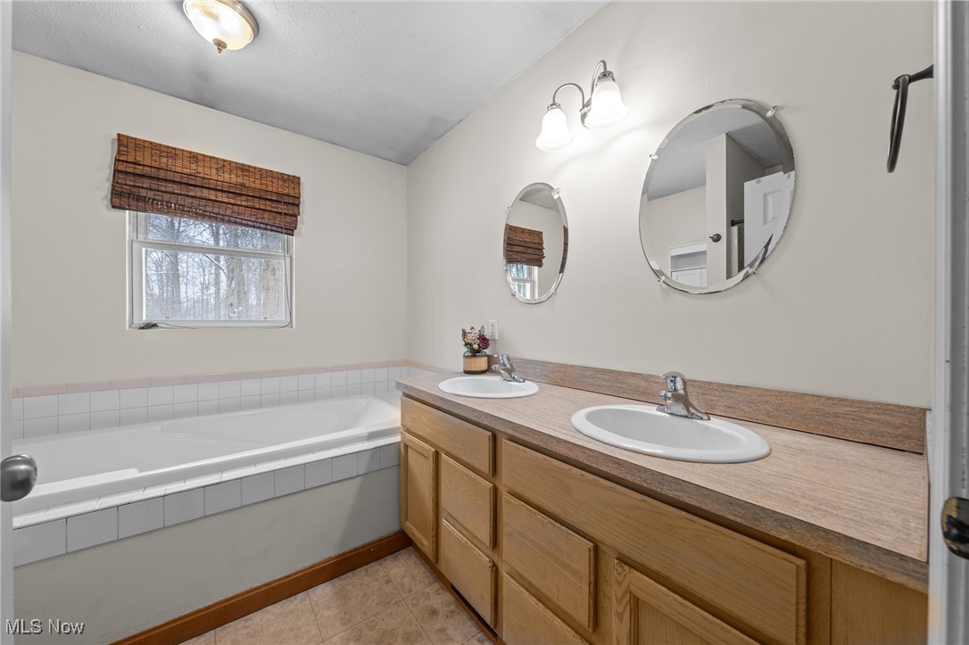10641 Gilbert Road Newton Falls, OH 44444 - Photo 25 of 46 Bathroom with tile patterned flooring, vanity, and a tub