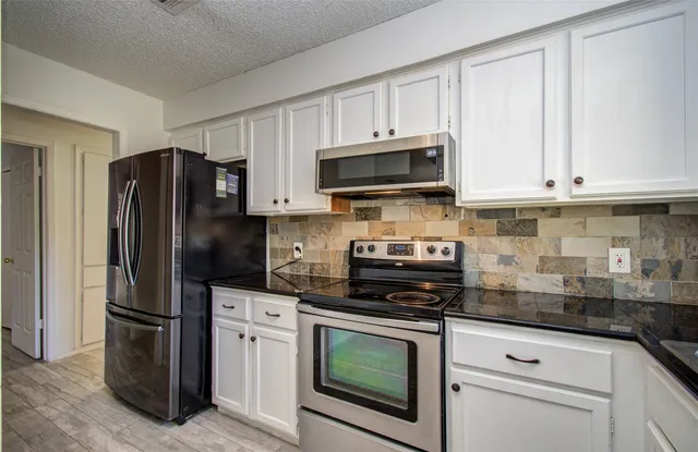 a kitchen with cabinets stainless steel appliances and a sink