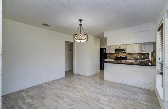 a view of a kitchen with a sink cabinet and refrigerator