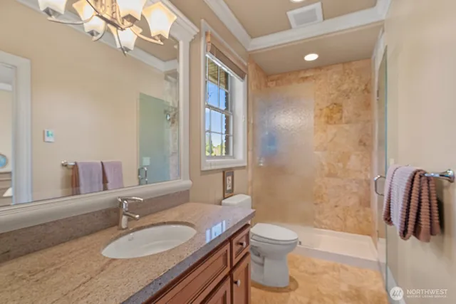 a bathroom with a granite countertop sink toilet a mirror and shower