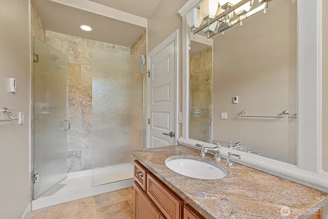 a bathroom with a granite countertop shower sink and mirror