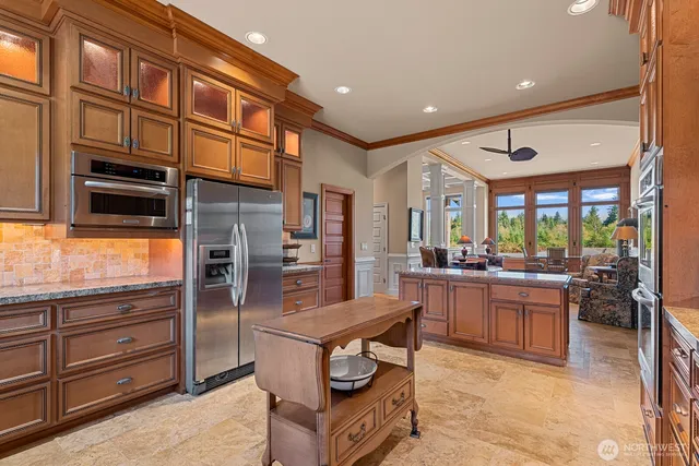 a kitchen with stainless steel appliances kitchen island granite countertop a refrigerator and cabinets