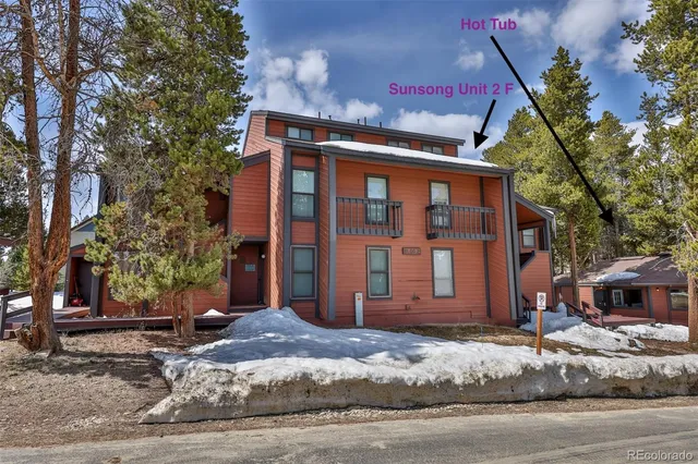 a front view of a house with a tree