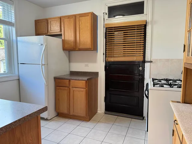a kitchen with a refrigerator and a stove top oven