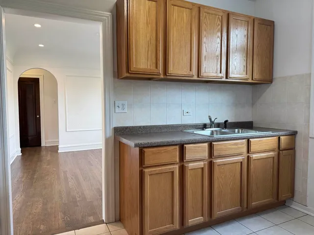 a kitchen with stainless steel appliances granite countertop a sink and cabinets with wooden floor