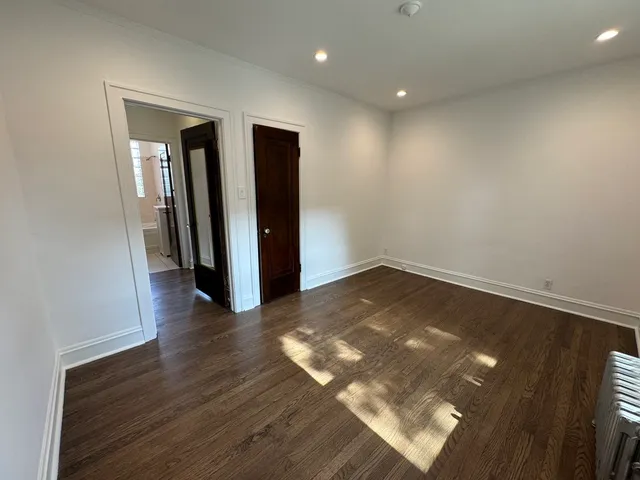 an empty room with wooden floor and closet