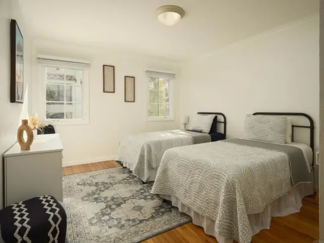 a bedroom with two beds and a dresser