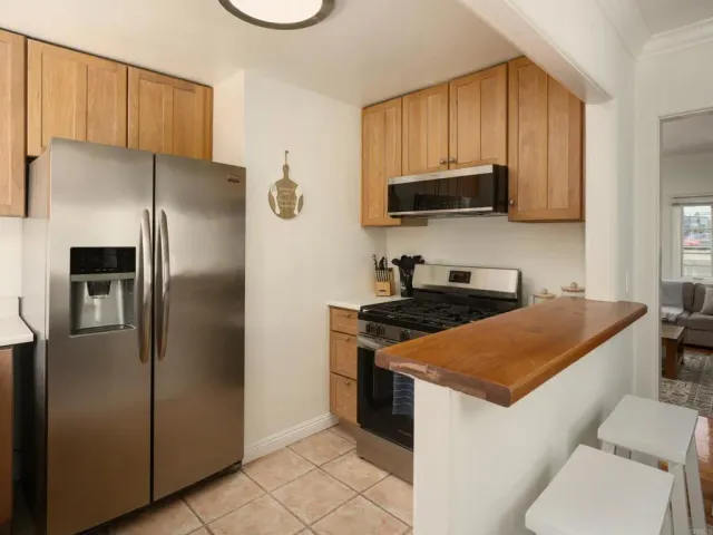 a kitchen with stainless steel appliances granite countertop a refrigerator a stove a sink and a microwave