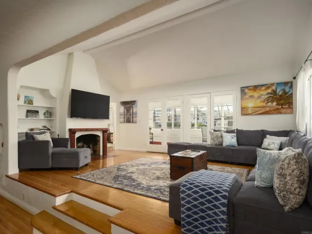a living room with furniture a flat screen tv and a fireplace