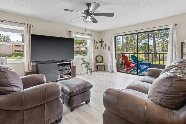 a living room with furniture a large window and a flat screen tv