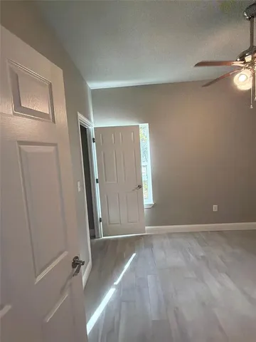 an empty room with windows and fan