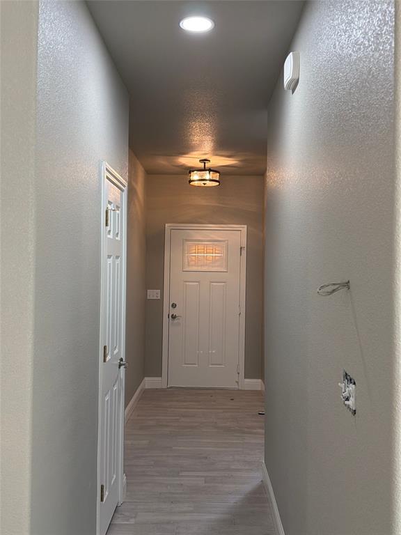 411 Hamilton Road Mineral Wells, TX 76067 - Photo 3 of 12 a view of a hallway with a chandelier fan and wooden floor