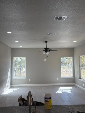 a view of a hallway with a chandelier fan and wooden floor