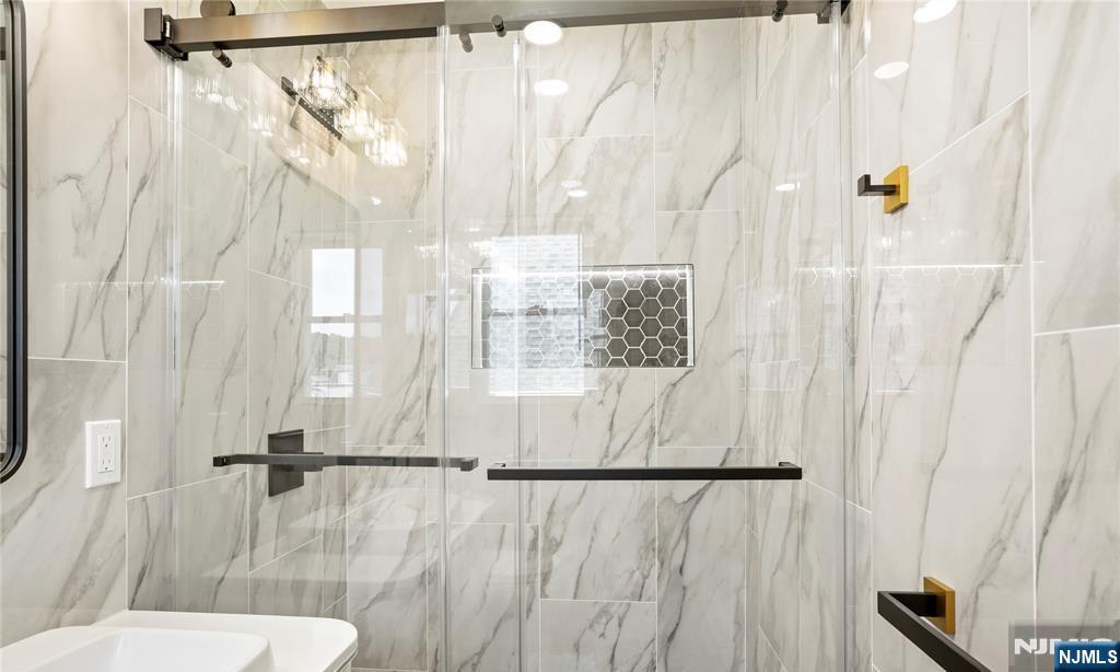 243 Hayward Place Wallington, NJ 07057 - Photo 6 of 9 a bathroom with a sink and glass door