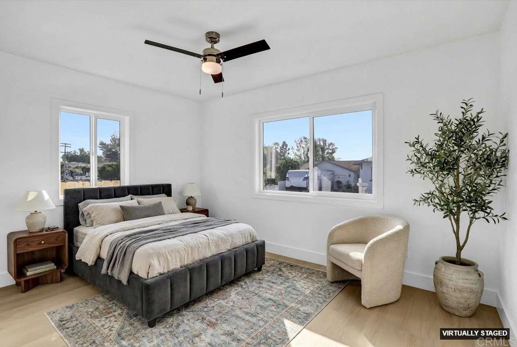 323 South 65th Street Encanto, CA 92114 - Photo 26 of 44 a bedroom with a bed a couch and a potted plant