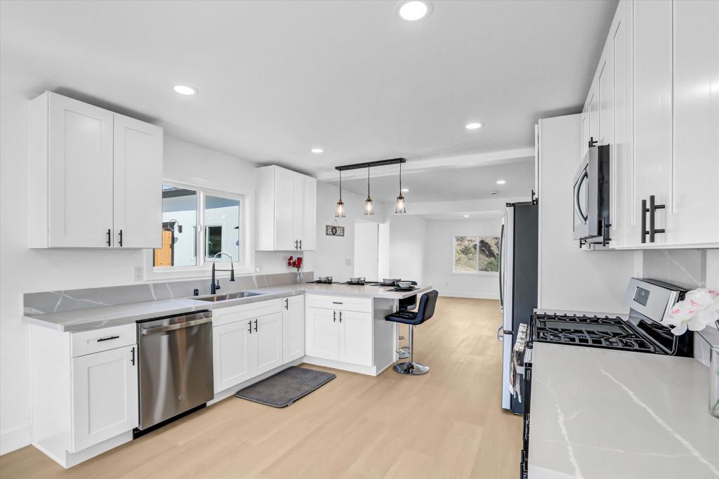 323 South 65th Street Encanto, CA 92114 - Photo 10 of 44 a kitchen with a stove a sink a refrigerator and cabinets